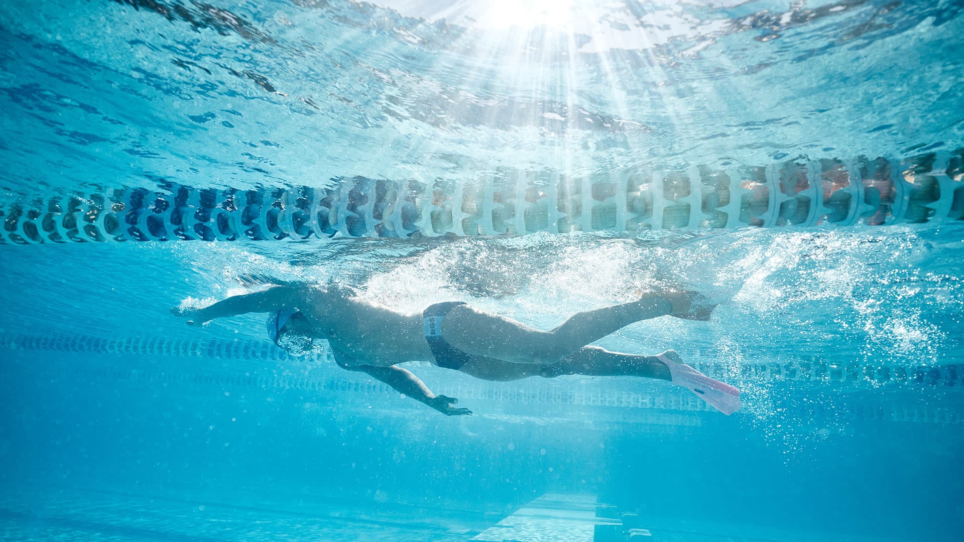 Underwater image of male swimmer at Centenary Pool with light rays filtering through the water
