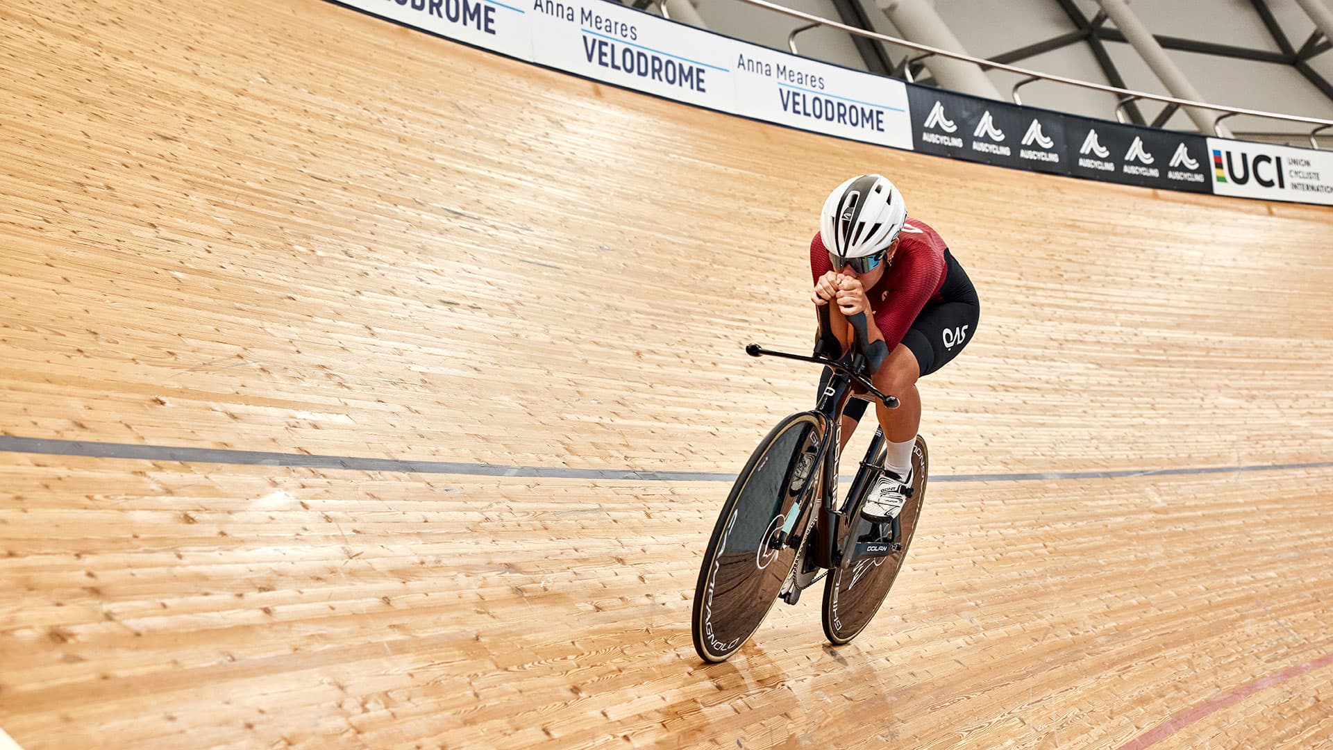 A cyclist rides on an indoor velodrome track