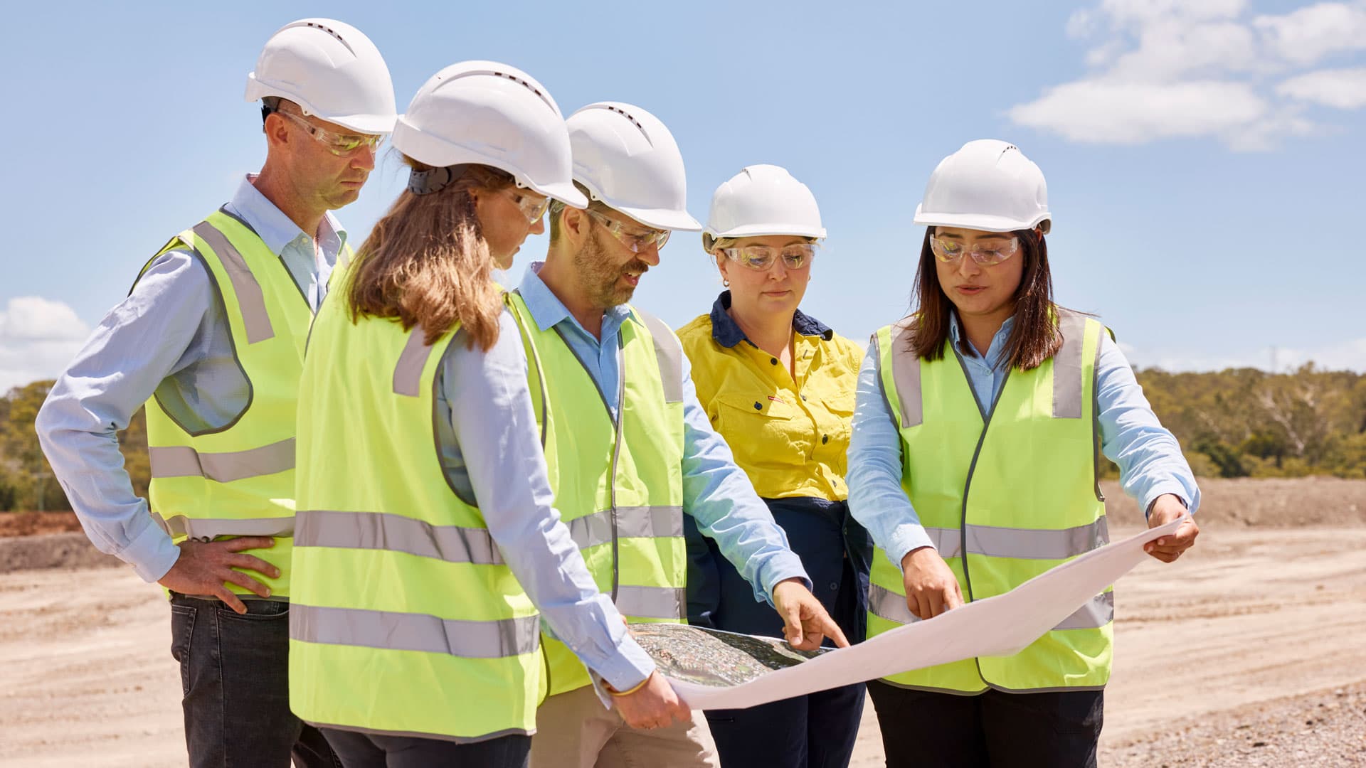 GIICA construction workers looking at plans while on a construction site