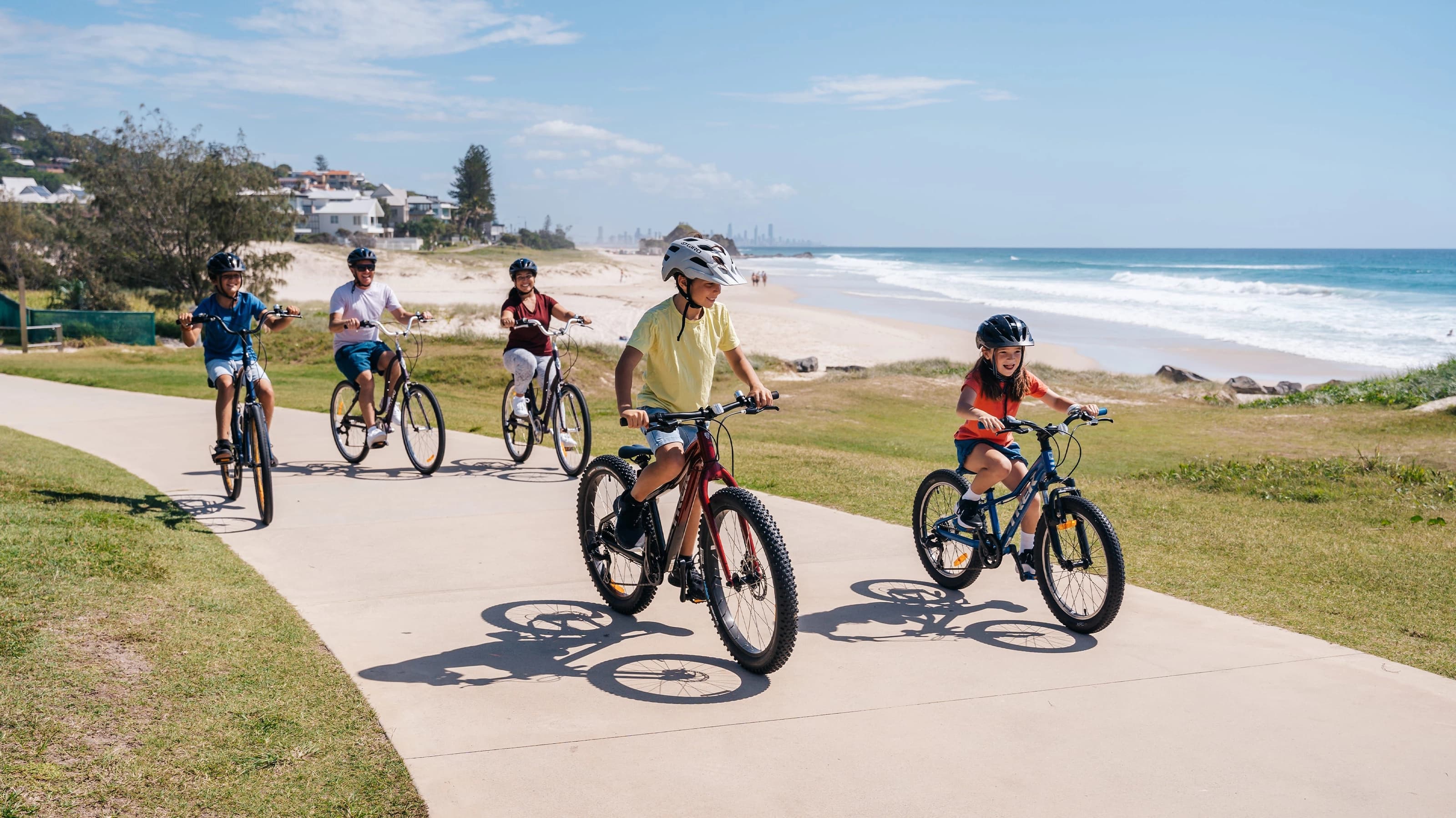 Children riding bicycles next to the beach